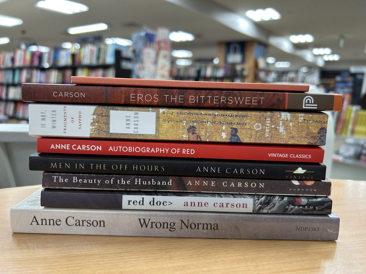 本屋さんの机の上に積まれた、アン・カーソンの英語の本