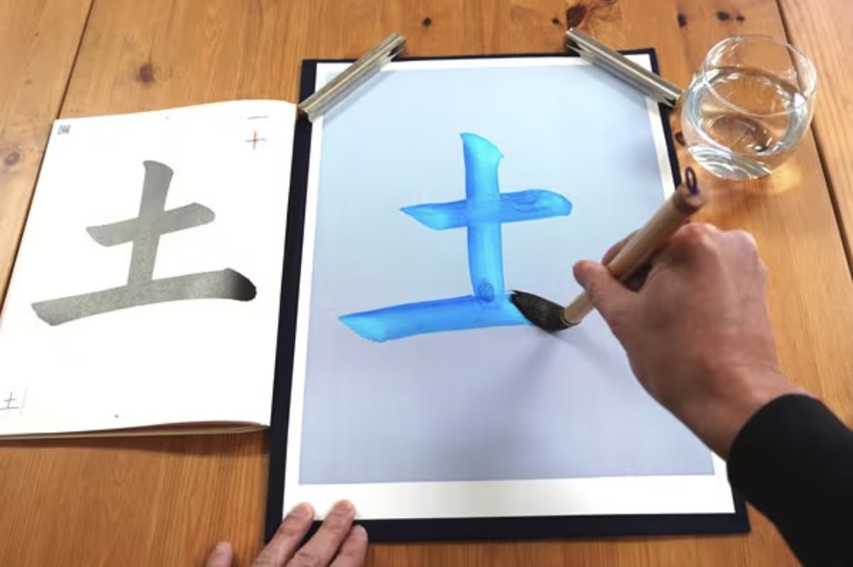 水だけで「土」の字を書いている手元