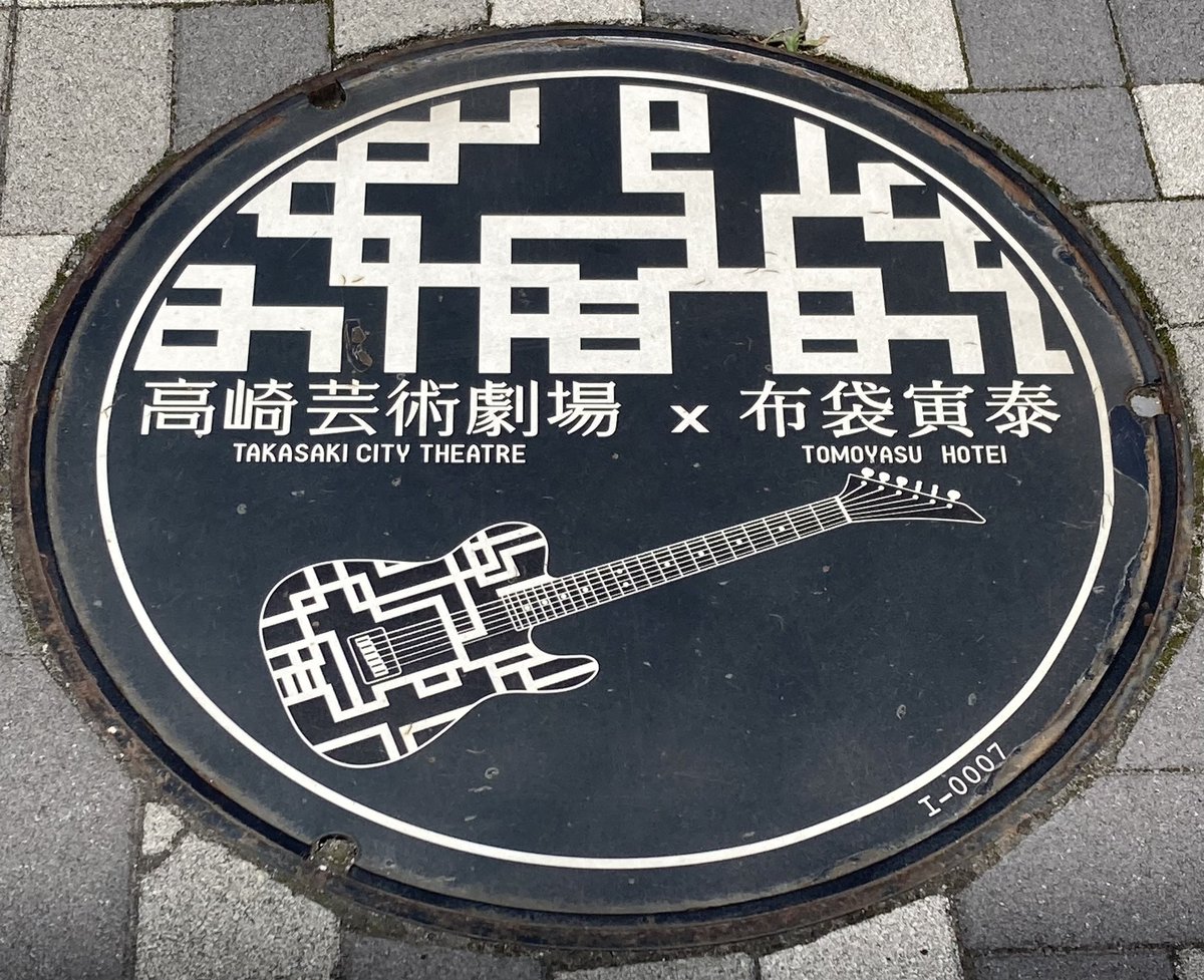 「高崎芸術劇場×布袋寅泰」と書かれた、G柄とギターの絵のマンホールの蓋