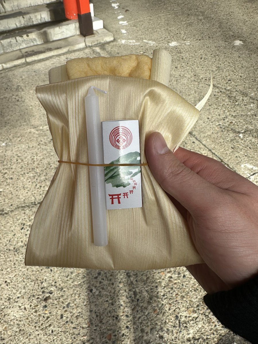 経木に包んだ油揚げに、ローソクとマッチが添えてある
