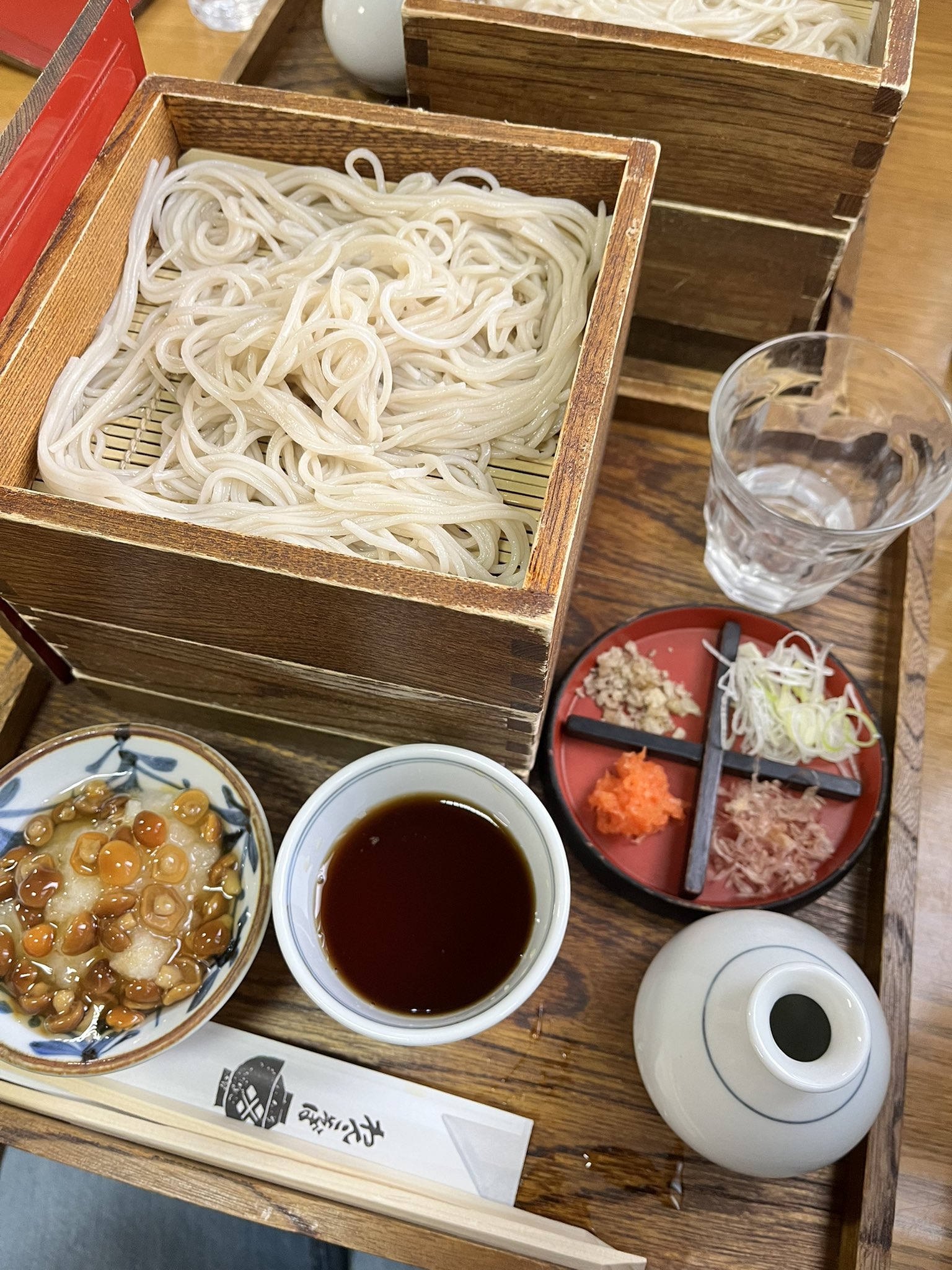 二段のせいろのそばの横に、そばつゆと薬味、白いとっくりとグラスが並んでいる