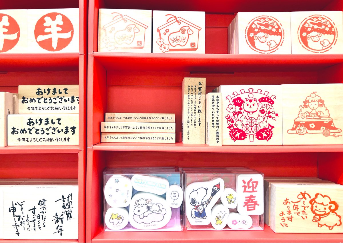 書店の売り場の赤い棚に、年賀のスタンプがたくさん並んでいる